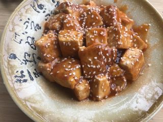 14、做道小朋友也爱吃的酸甜豆腐,豆腐倒入盘中，洒上白芝麻装饰。
