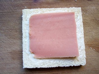 3、火腿西多士,放上一片火腿。