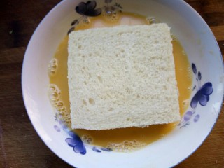 8、火腿西多士,将土司每一片都裹上牛奶蛋液。