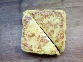 11、火腿西多士,将煎好的西多士沿着对角线切开。