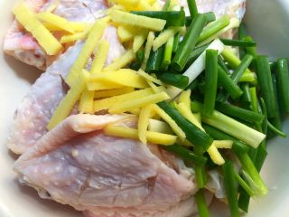 3、香酥鸡翅,把鸡翅放入碗里，加入生姜和葱段。