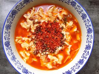 18、水煮肉片,将花椒和辣椒面铺在表面。