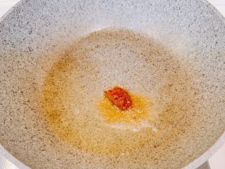 4、蒜苔炒肉,冷锅热油,放入1勺郫县豆瓣酱,翻炒至化开