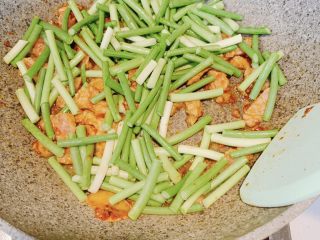 7、蒜苔炒肉,加入蒜苔,翻炒均匀