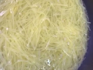 4、炝拌土豆丝,锅中水开下入土豆丝烫三十秒