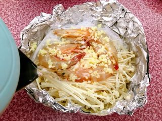 11、锡纸金针菇粉丝虾煲,兑入适量开水。因为粉丝比较吸水,所以要兑入开水。