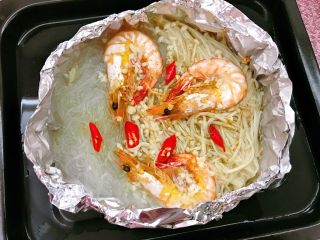 13、锡纸金针菇粉丝虾煲,20分钟后拿出,撒上孜然粉,淋上酱油,香油,放上小米椒。再烤8分钟。