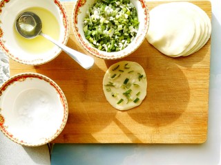 6、香脆饺子皮葱油饼,把水饺皮放在板上，抹一层花生油和少许盐，盐不要放多了，因为每层都要放盐，盐放多了会很咸哦，花生油也是如此，薄薄的抹一层就可以