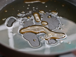 4、黄焖鸡米饭,锅中放油烧至五成热,下入冰糖小火不停的翻炒至冰糖融化,颜色呈琥珀色