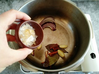 7、东北大酱骨,倒入冰糖 翻炒几下（加冰糖是为了提色）。