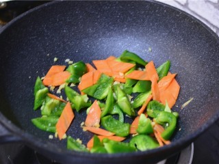 11、溜肉段,锅中留少许底油,姜蒜爆香,加入青椒,胡萝卜翻炒均匀。