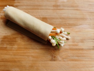 6、豆皮金针菇卷,把豆皮卷起来,卷的时候一定要卷紧,防止烹饪时散掉。