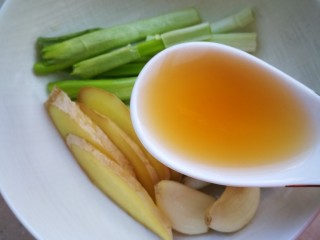 5、红烧带鱼#年年有余#,碗里放入葱姜，蒜，一勺料酒。