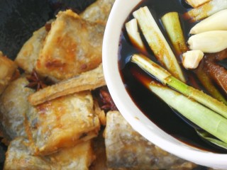 9、红烧带鱼#年年有余#,倒入调好的料汁。晃动均匀，让料汁均匀的裹在带鱼上
