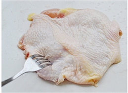 5、黑椒柠汁煎鸡扒,鸡腿放入容器里，加入黑胡椒碎，盐，挤一半的柠檬汁，另一半切成小块，再加入洋葱丝和蒜片。