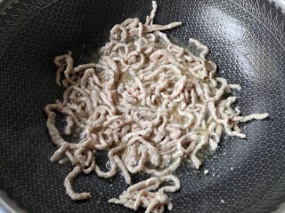 9、京酱肉丝,下入腌制好的肉丝，迅速滑开，炒至变色。