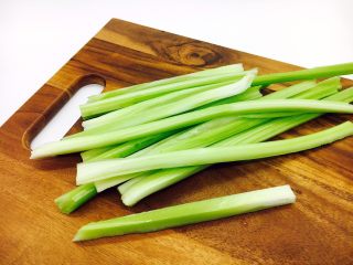 2、#感恩节食谱# 西芹百合炒腰果,把西芹先切成1厘米左右宽的长条。