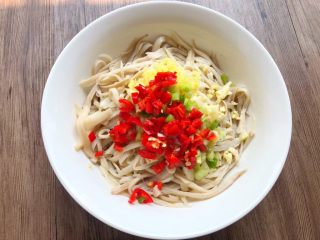 6、手撕杏鲍菇,把葱白、姜末、蒜末、红辣椒碎放到杏鲍菇上面。