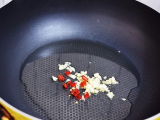 4、孜然杏鲍菇,锅中倒入适量的食用油烧热，放入蒜末和干红辣椒爆香