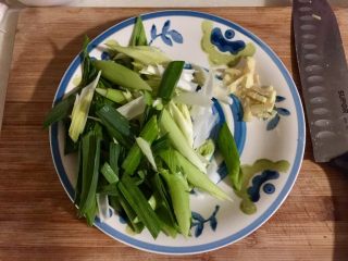 3、蒜苗木耳炒猪耳,姜切姜丝，蒜苗蒜白部分用刀背拍一下，然后斜刀切段