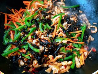 11、鱼香肉丝,放入配料胡萝卜、青椒、木耳丝大火快速翻炒