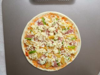 8、培根薯角薄底披萨,然后在面饼上刷一层意粉酱，均匀铺上芝士、薯角、培根和青椒丝。