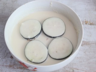 7、煎茄盒,将茄盒放入面糊中,裹上面糊。