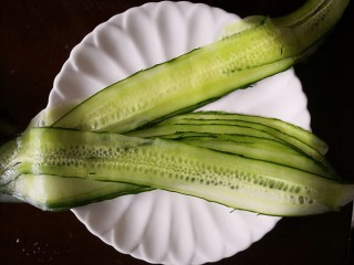 1、【响油心形黄瓜】,先将黄瓜刨成长片。