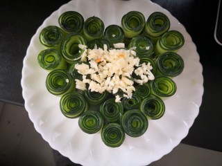 4、【响油心形黄瓜】,摆上蒜泥。