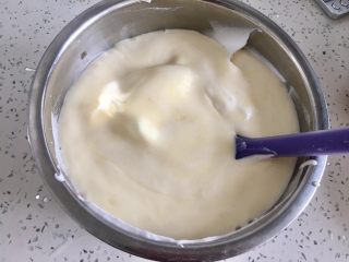 15、虎皮蛋糕卷,把翻拌好的蛋黄糊放入蛋白霜盆里，用刮刀翻拌均匀。