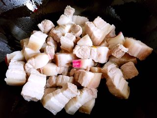 6、红烧肉,锅内放油烧至五成热，放入肉块翻炒片刻。