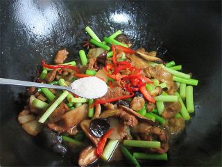 11、五花肉炒蒜薹,撒入红椒丝装饰一下,加入一勺盐翻炒即可关火装盘