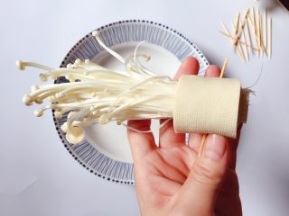 4、豆皮金针菇,然后用豆皮卷住金针菇，用牙签固定备用