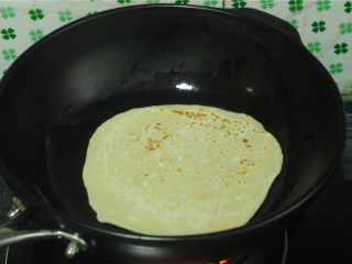 8、烫面牛柳卷饼,锅刷油，加热后转中小火，将擀薄的饼放进去，煎至一面微微变黄，出现少许焦黄的花纹，翻面，两面都煎熟