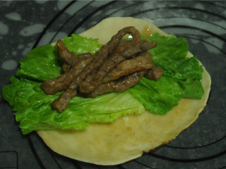 12、烫面牛柳卷饼,处理好的生菜和牛柳放在卷饼上，裹起来即可