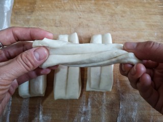 12、霜糖油条,用手捏着两端拉成长条，可以稍微拧一下。