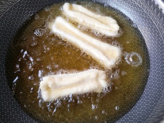 13、霜糖油条,锅中适量油，烧至5成热，把油条生坯下油锅。