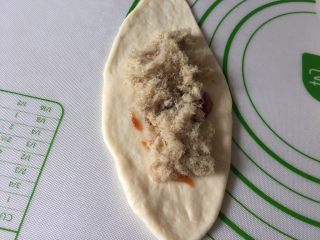 8、肉松小面包,拿一个面团擀成牛舌状，抹上披萨酱或沙拉酱，上面再铺一层肉松。