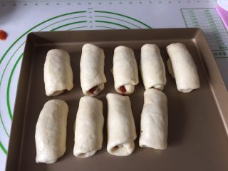 10、肉松小面包,全部包好收口朝下放在烤盘里进行二发，温度38度左右，可以在烤箱里发酵，烤网上放一碗温水保证湿度。