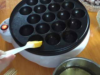 4、佳丽章鱼小丸子,在锅上刷一层油预热