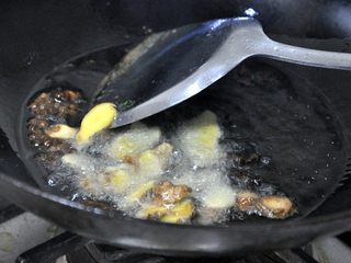 5、孜然土豆条,倒入姜、蒜，继续炒香。