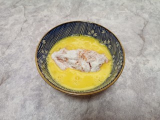 6、香酥炸鸡翅,然后放入鸡蛋液里面浸泡几秒钟,沾满蛋液。