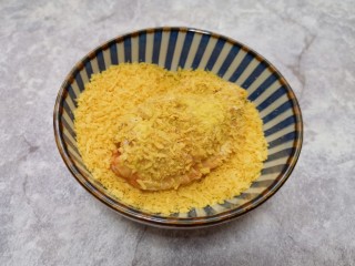 7、香酥炸鸡翅,最后将沾满蛋液的鸡翅放入面包糠里面打个滚,沾满面包糠。