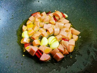 5、好吃到舔盘的黄瓜火腿丁,加火腿肠翻炒均匀。