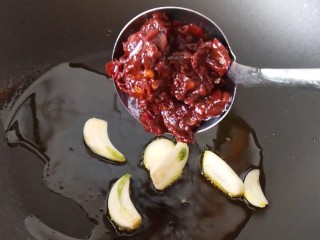 8、红烧鸡爪,放入蒜瓣炒香放入郫县豆瓣辣酱炒出红油