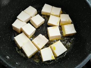 6、香菇焖豆腐,热锅烧油放入豆腐中大火煎制一分钟
