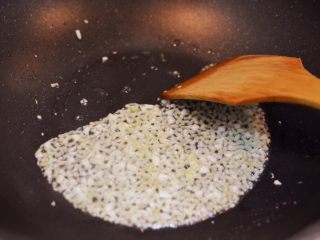 10、金针酸汤肥牛,锅中油烧热，放入姜末和蒜末爆香。