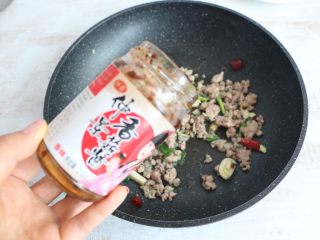 9、酱香干煸豆角,出香味后，放入2大勺香辣酱翻炒。