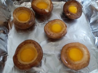 6、香菇烤太阳,烤盘内铺锡纸，香菇平铺在烤盘里，把鹌鹑蛋小心的磕在香菇内