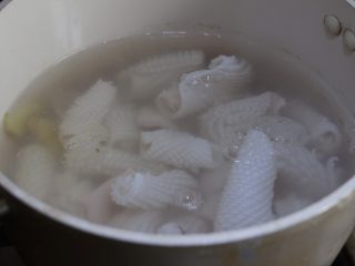 6、酱爆鲜鱿,清水加姜片和料酒烧开关火,迅速加入切好的鱿鱼汆烫。